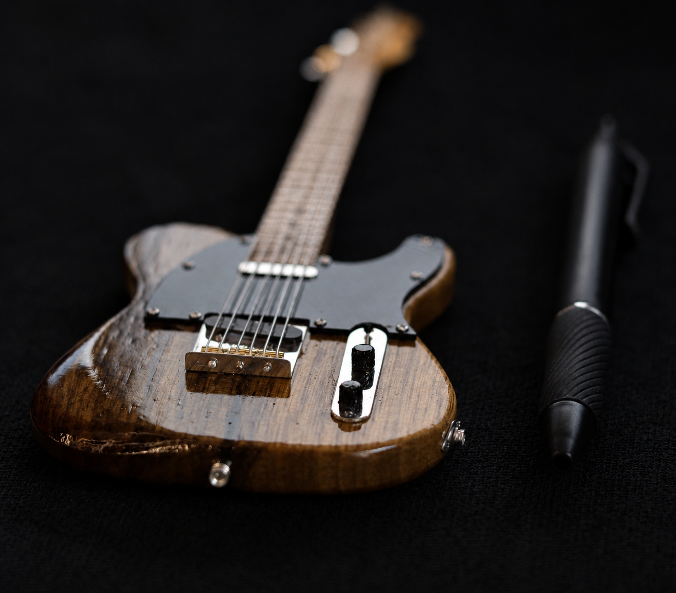 Angled view of the miniature Telecaster pickguard, pickups and control knobs