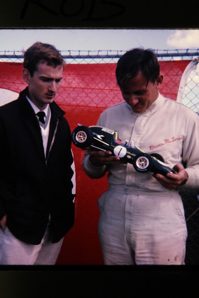 Bruce McLaren examining the miniature Lotus race car trackside